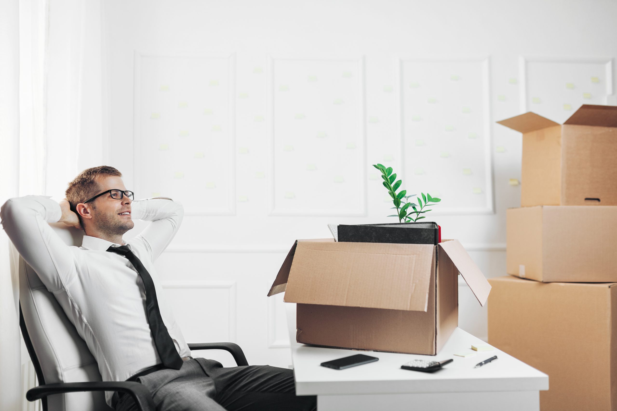 Expert Removals A man sitting at a desk with boxes in front of him.